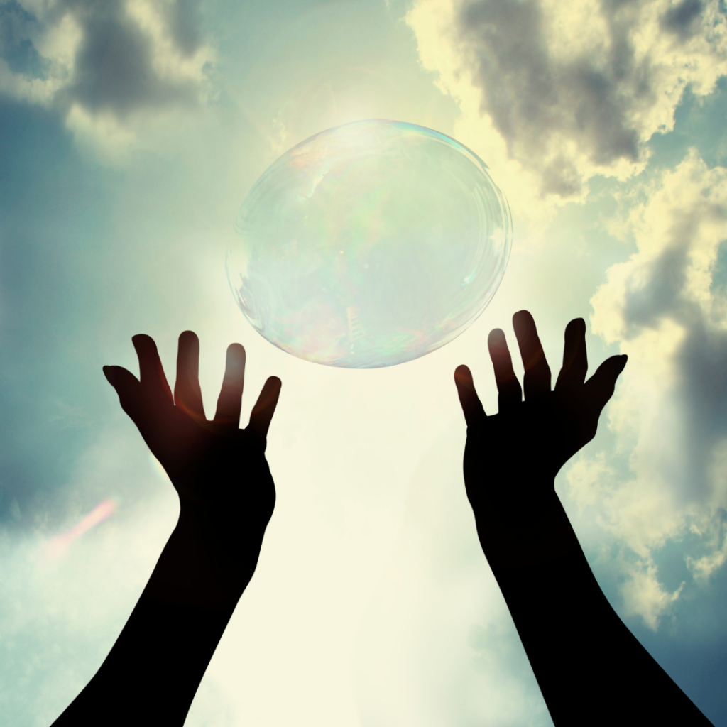 a bubble in the sky and two hands trying to touch it